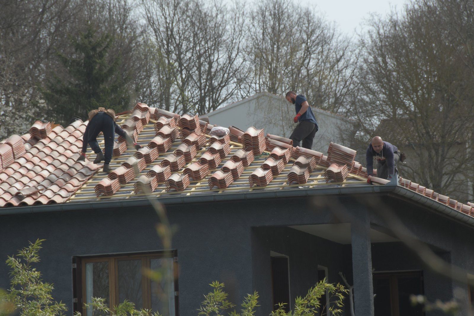 Artisan couvreur procédant à la pose des nouvelles tuiles à Pamiers